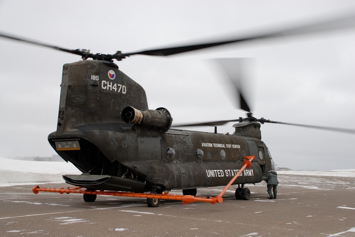 CH-47D Chinook helicopter 90-00180 with the Helicopter Icing Spray System (HISS) installed and operating in an extreme cold environment preparing to spray ice. An aircraft requiring analysis of its deicing capabilities would fly approximately 150 feet below the HISS aircraft as it sprayed water. The water would freeze and ice would accumulate on the test aircraft. The aircrew of the test aircraft could then evaluate the deice capabilities of their aircraft.