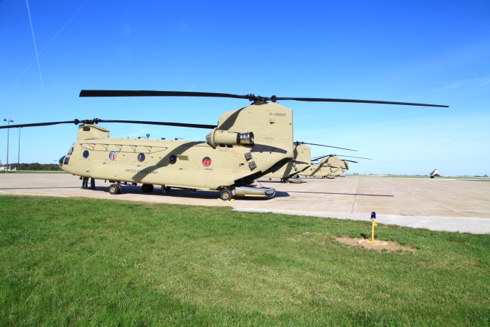 20 September 2012: 10-08802 and flight rests on the ramp at Quincy Regional Airport, Illinois, during a fuel/lunch stop. The large black and white triangular shaped object to the right of the helicopters is called a wind tetrahedron and indicates the direction of the wind on the airfield. It is used by the pilot as an aid in determining the appropriate runway to use.