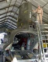 Chief Warrant Officer 2 Joshua Howe stands next to the Chinook that absorbed a rocket hit June 8 near Shkin, Afghanistan.