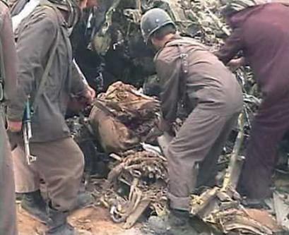 Afghans work through the wreckage of a crashed U.S. military CH-47D Chinook helicopter.